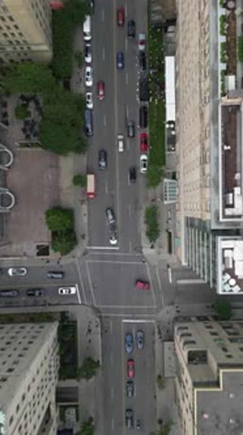 Aerial drone shot over downtown Montreal, top-down view of busy city streets with cars in traffic, s