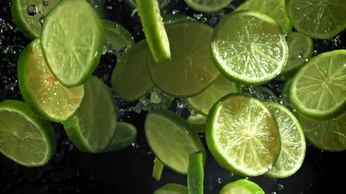 Slices of Fresh Lime Floating with Water Droplets