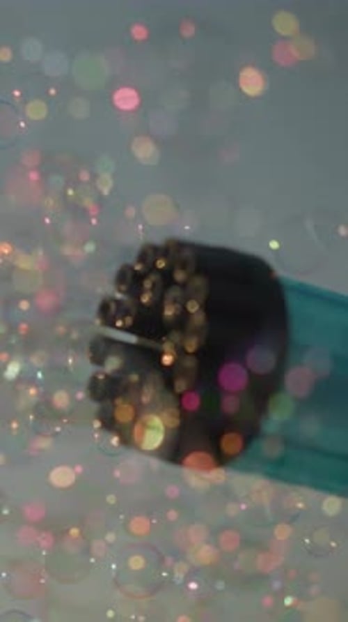 CloseUp of Bubble Gun Releasing Colorful Bubbles Under Clear Sky