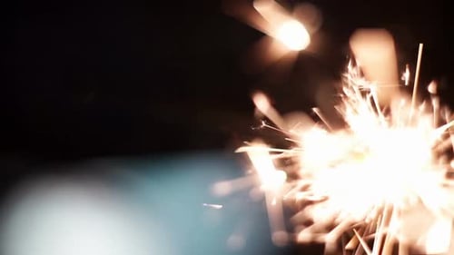 Sparkler Emitting Glowing Sparks on Dark Background