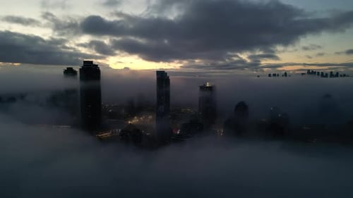 City Skyline Emerging from Fog at Sunrise