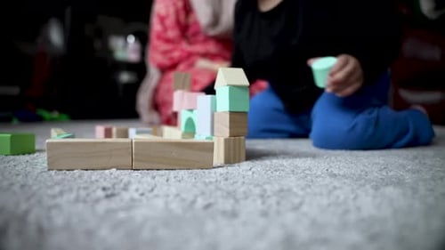 Young Child joyfully building with wooden toy blocks on carpet