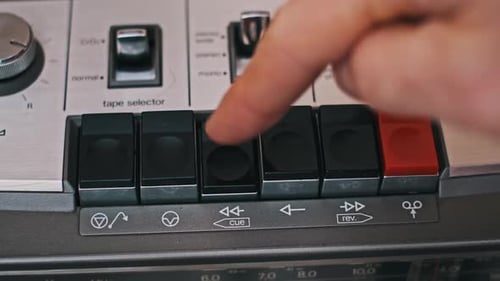 Pressing Rewind Button on Vintage Cassette Player