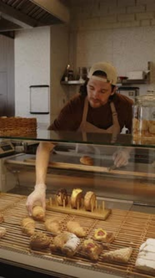 Baker Putting Pastry in Display Counter for Sale in Cafe