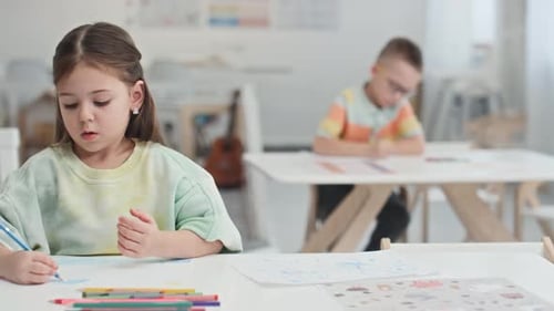 Children Drawing Together in a Bright Classroom
