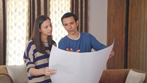 Indian husband discussing house plan with wife
