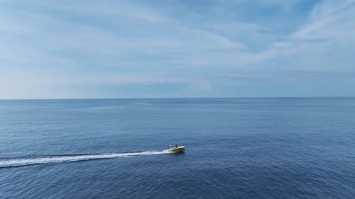 Aerial Video of a Motorboat Cruising at High Speed Towards the Harbor Leaving White Foam on the Deep