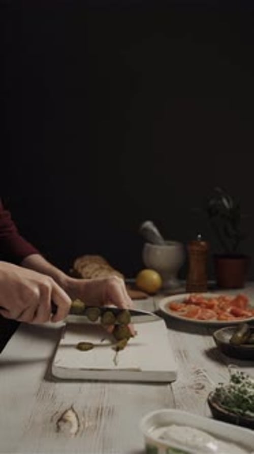 Person Slicing Pickles on Board Preparing Food Indoors
