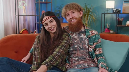 Smiling Couple Cuddling Together on Couch Indoors