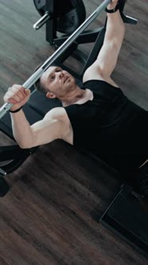 Strong healthy bodybuilder exercising in gym.