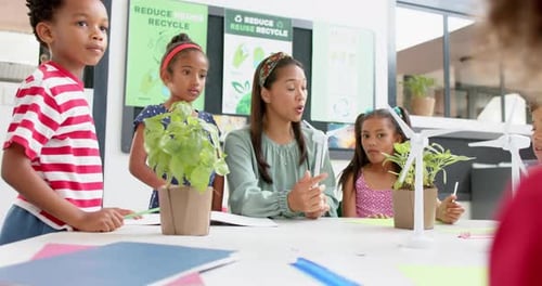 In school, teacher discussing wind energy with students using wind turbine models