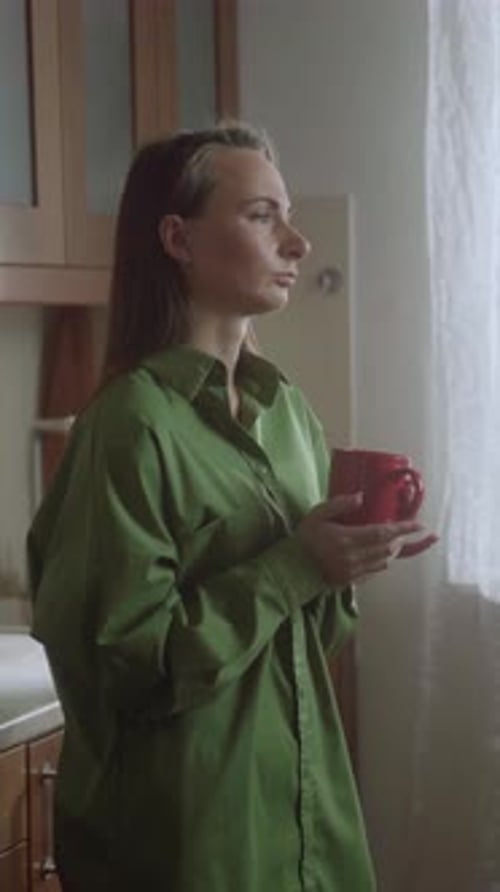 Woman Enjoys Morning Coffee in Kitchen