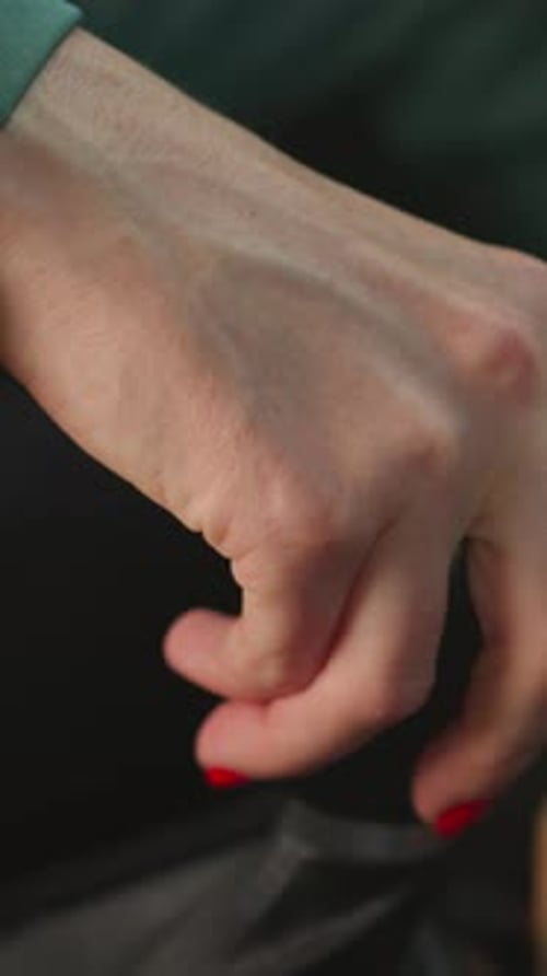 Mão de mulher em jaqueta verde mudando de marcha para dirigir carro