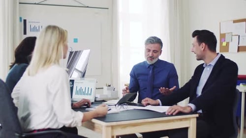 Diverse business team collaborating on a laptop project in a modern office space