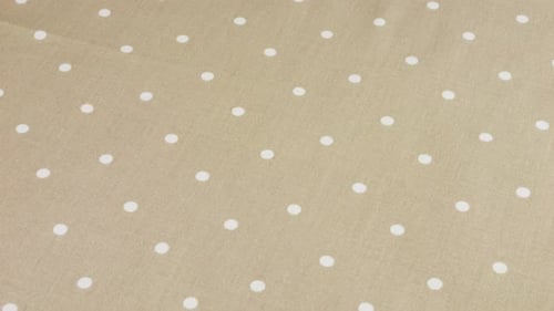 Top view of the lovender grey with white polka dots cotton fabric rotated on the display case