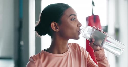 Woman, drinking water and fitness in gym with health, thirsty and wellness with workout
