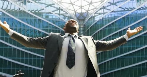 Successful Man Celebrating in Front of Glass Building