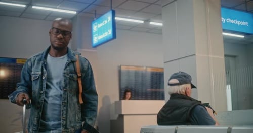 International Airport Terminal Man with Luggage Sitting Waiting for Airplane Flight