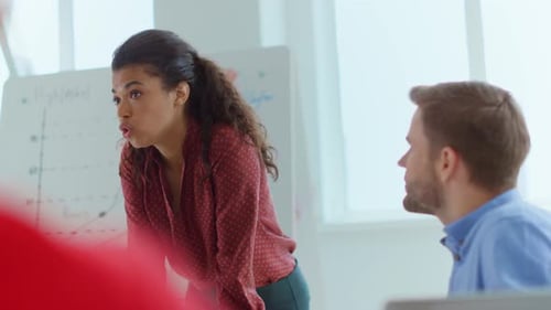 Woman Presenting Data to Colleagues in Modern Office