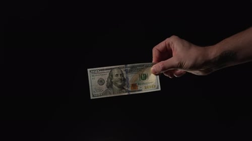 Hand Holding One Hundred Dollar Bill on Black