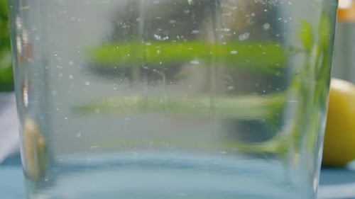 Lemon Slice Dropping into Refreshing Water Glass