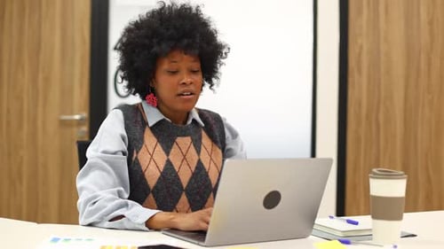 Woman Working at Laptop in Office at Desk
