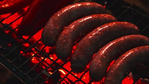 Sizzling Grilled Sausages Cooked on the BBQ Enhanced By a Warm Charcoal Glow and Flame