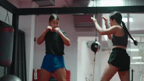 Two Fit Women Practicing Boxing Drills at Gym