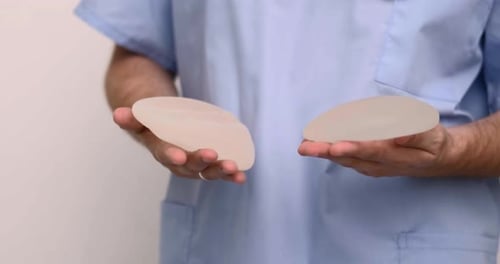 Cosmetic Surgeon Holding Silicone Breast Implants