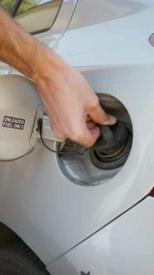 Hand Closing a White Car's Fuel Tank Door