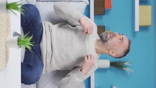 Vidéo verticale de l'homme qui suffoque à cause de la chaleur à la maison.