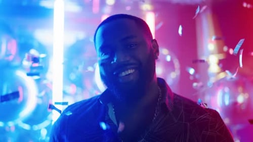Closeup Afro Guy Standing In Club. Portrait Of Smiling Male Person Looking At Camera On Neon Lamp...