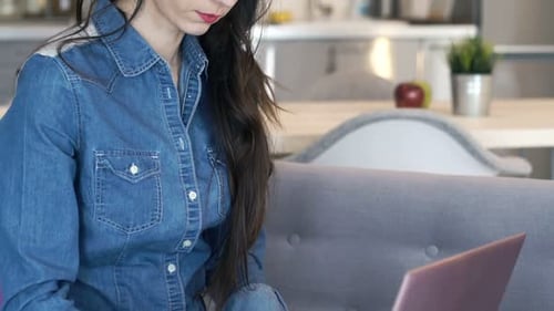 Woman Typing on Laptop While Sitting on Couch