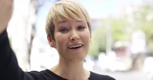 4k video footage of a young woman making a video call while out in the city