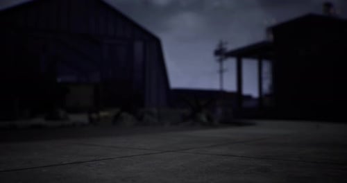 Dark Industrial Setting with Blurred Foreground During Twilight Hours