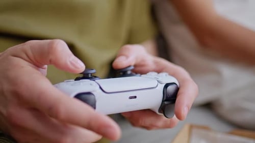 Hands Playing Video Game with Controller Indoors
