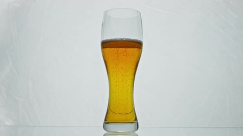 Glass Filled Golden Beer with Raising Up Bubbles in Super Slow Motion Close Up