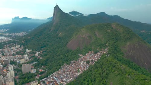 Vista aérea de montanhas verdejantes e paisagem urbana no Rio de Janeiro com foco em uma área densa