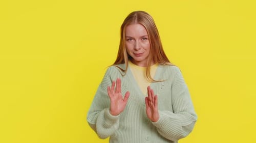 Woman Gesturing Stop on Yellow Background
