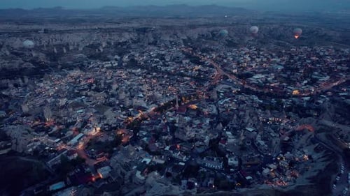 Aerial Night View of City with Hot Air Balloons