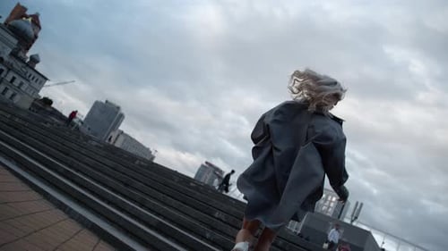 Woman walks up outdoor stairs, urban city