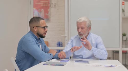 Colleagues Discussing Business Data on Tablet in Office