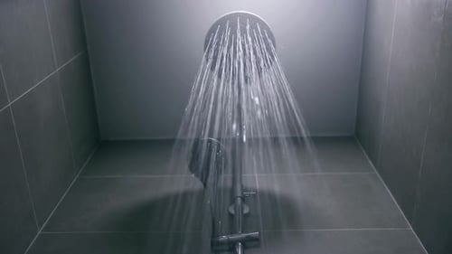 Water Flowing From Shower Head in Modern Bathroom