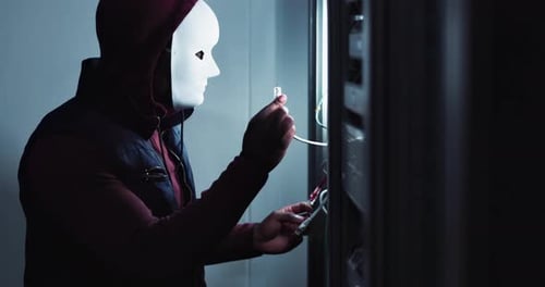 Le codage, un pirate informatique et une personne masquée dans la salle des serveurs constituent un risque pour la cybersécurité, les câbles et le centre de données