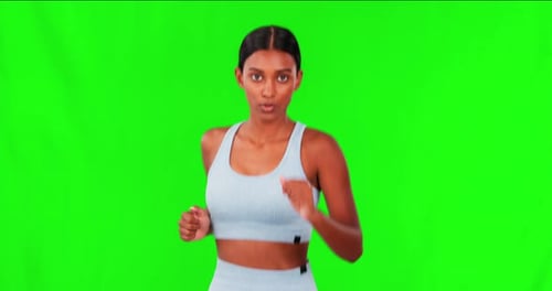 Woman, running and fitness on green screen in workout or cardio exercise against a studio