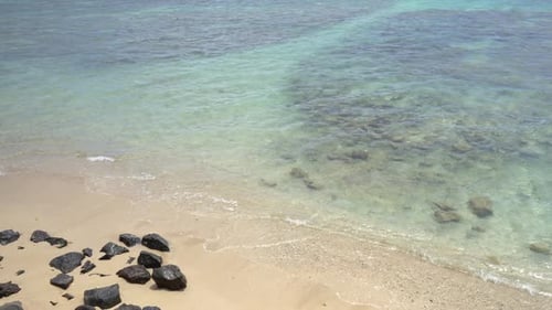 Calm ocean surface and idyllic tropical island sandy beach. Turquoise, transparent and crystalline o