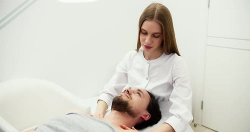 Female Master Doing Therapeutic Massage of the Head and Neck for Man