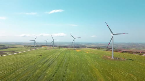 Wind Turbines Rotating in a Green Field, Aerial View