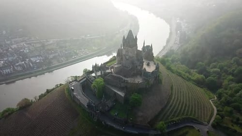 Reichsburg cochem castle overlooking moselle river in morning mist