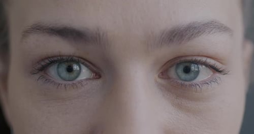 Closeup Slow Motion Portrait of Beautiful Female Eyes Looking at Camera with No Emotion